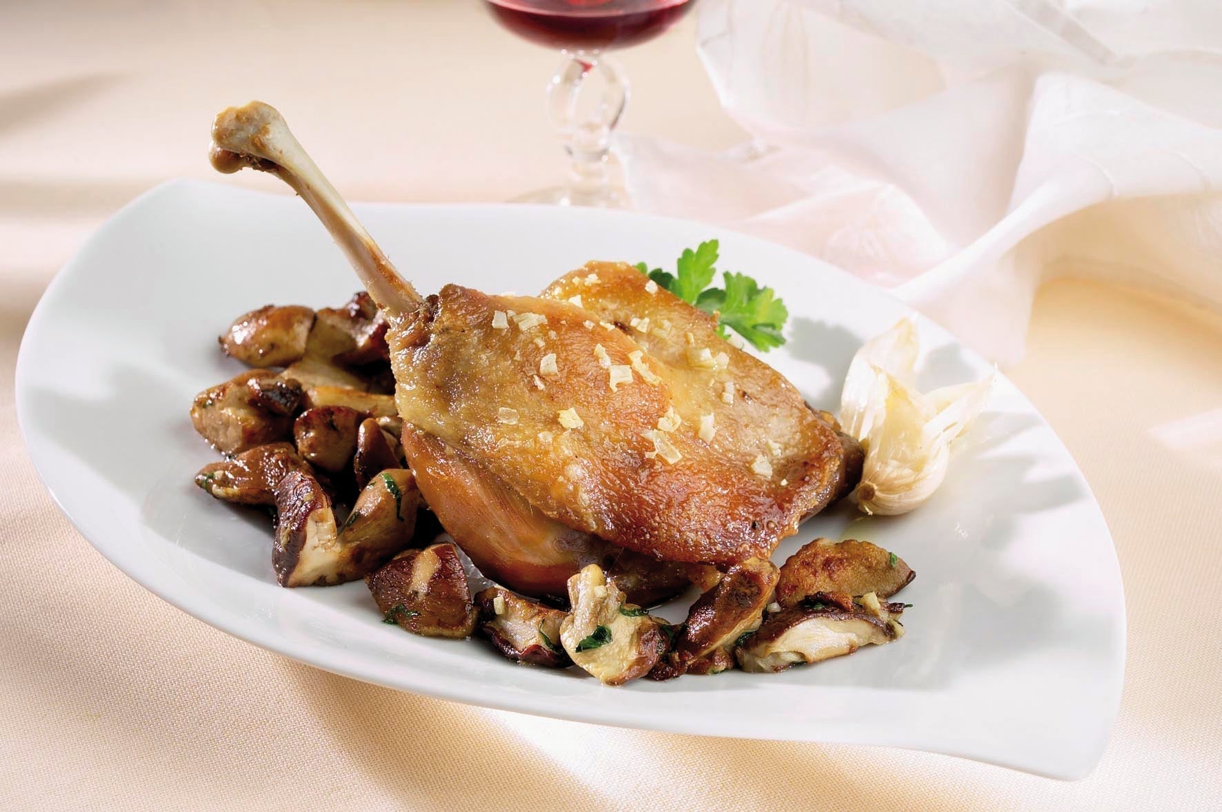 Entenconfit serviert mit Steinpilzen und Rotwein